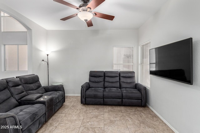 living room with a ceiling fan and baseboards