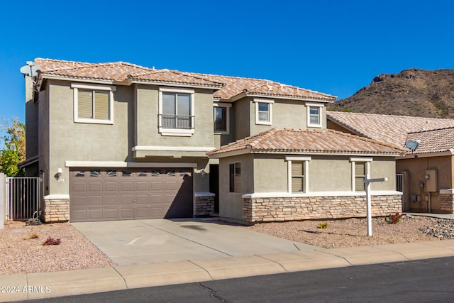 view of front of house with stone siding, a tiled roof, concrete driveway, and stucco siding