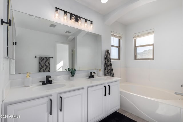 full bathroom featuring double vanity, visible vents, a sink, and a bath