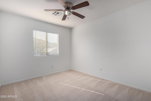 unfurnished room with baseboards, ceiling fan, visible vents, and light colored carpet