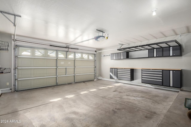 garage with a garage door opener and baseboards