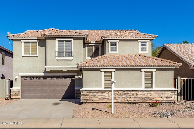 view of front of house featuring an attached garage, fence, driveway, stone siding, and stucco siding