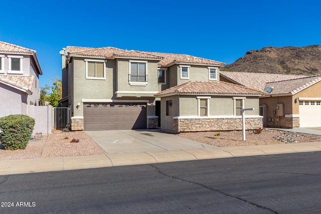 view of front facade featuring stone siding, a tiled roof, concrete driveway, and stucco siding