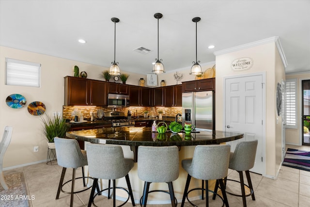 4200 E Narrowleaf Dr, Gilbert, AZ 85298 - kitchen featuring ornamental molding, a kitchen breakfast bar, stainless steel appliances, and visible vents