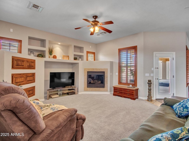 2724 W Fernwood Dr, Phoenix, AZ 85086 - living area featuring baseboards, built in shelves, visible vents, ceiling fan, and a tile fireplace