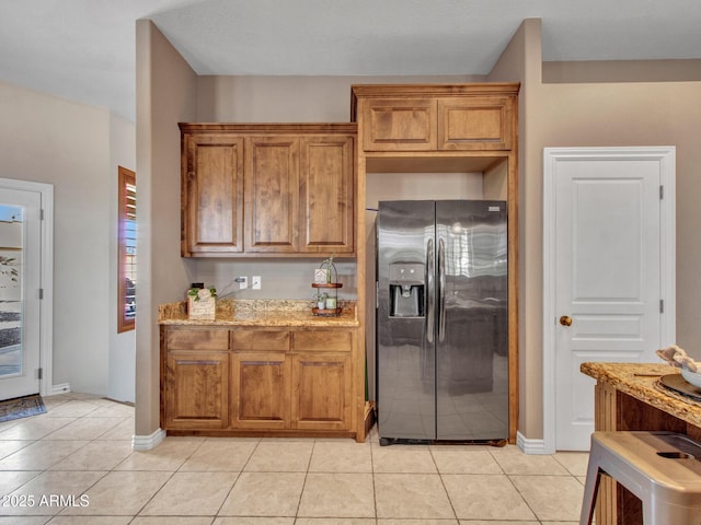 2724 W Fernwood Dr, Phoenix, AZ 85086 - kitchen featuring light tile patterned floors, baseboards, stainless steel fridge, brown cabinets, and light stone countertops
