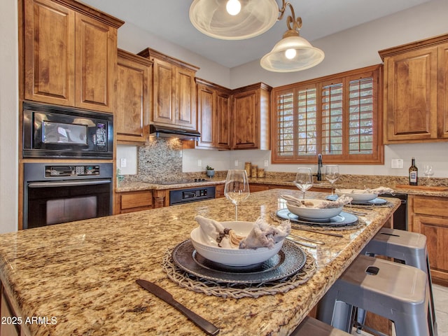 2724 W Fernwood Dr, Phoenix, AZ 85086 - kitchen with light stone countertops, a kitchen breakfast bar, black appliances, under cabinet range hood, and brown cabinets