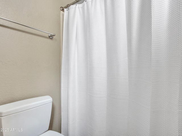 2724 W Fernwood Dr, Phoenix, AZ 85086 - bathroom featuring a textured wall, curtained shower, and toilet