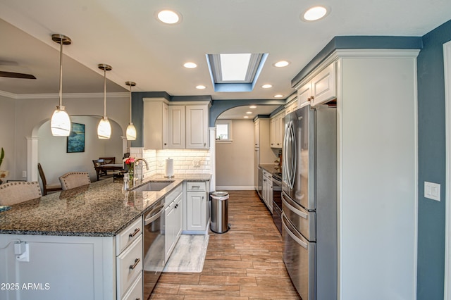 kitchen with white cabinetry, sink, a breakfast bar area, and stainless steel appliances