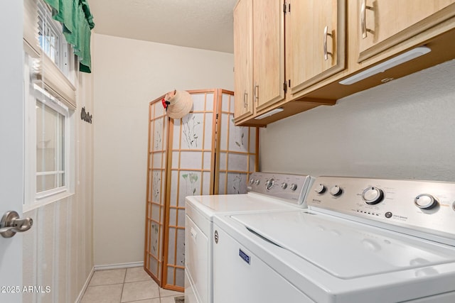 clothes washing area featuring cabinets, light tile patterned floors, and separate washer and dryer