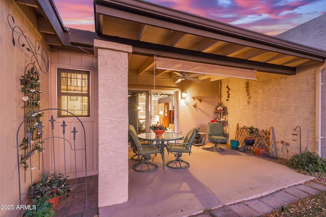 patio terrace at dusk featuring ceiling fan