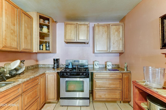 6541 N 54th Ave, Glendale, AZ 85301 - kitchen with stainless steel range with gas cooktop, light tile patterned flooring, a sink, open shelves, and a textured ceiling