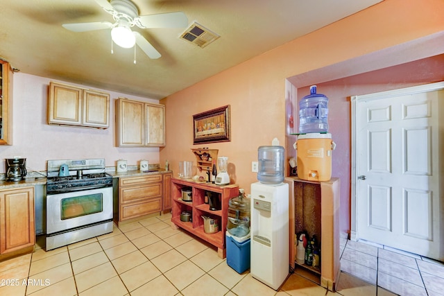 6541 N 54th Ave, Glendale, AZ 85301 - kitchen with stainless steel gas stove, light countertops, a ceiling fan, and light tile patterned floors