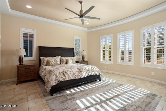 bedroom with ceiling fan and a raised ceiling