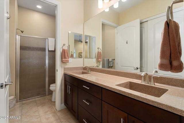 bathroom with tile patterned floors, an enclosed shower, vanity, and toilet