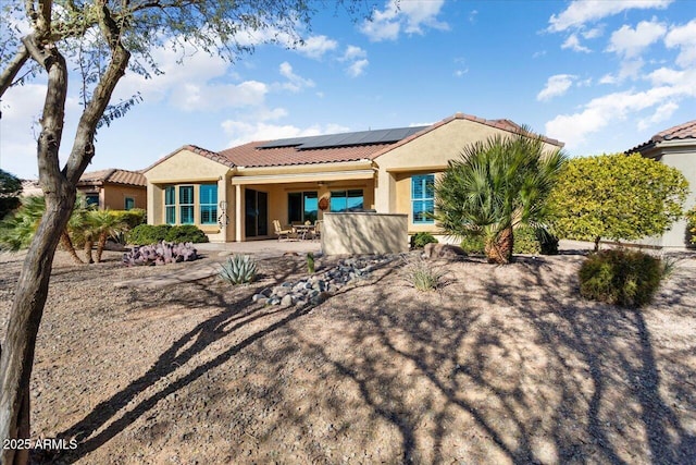 rear view of house featuring a patio and solar panels