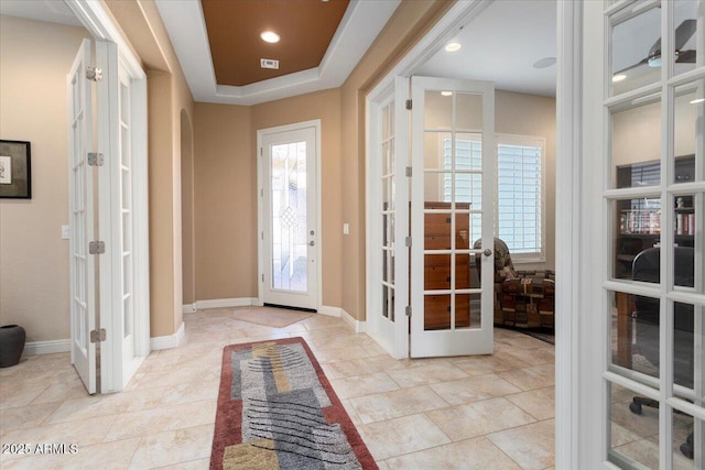 entrance foyer featuring a raised ceiling and french doors