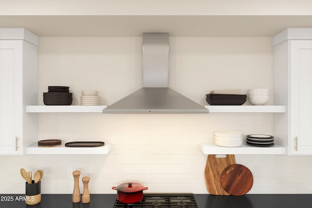 interior details with white cabinets, tasteful backsplash, and wall chimney exhaust hood