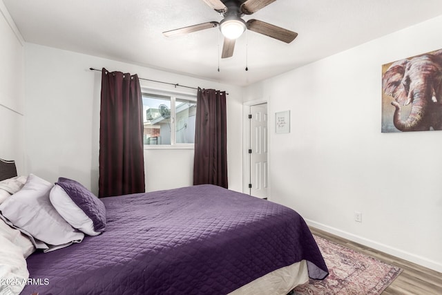 bedroom with wood finished floors, baseboards, and ceiling fan