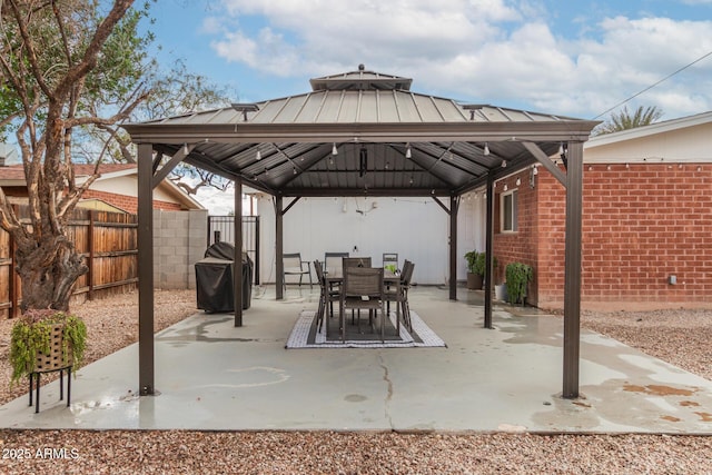 view of patio with a gazebo, outdoor dining space, a grill, and fence