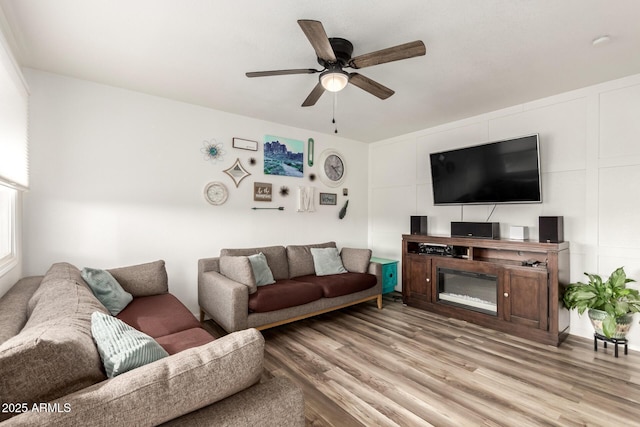 living room with light wood-type flooring and ceiling fan