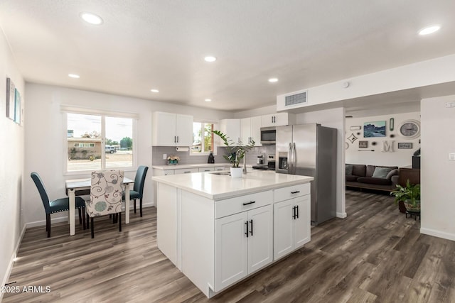 kitchen with visible vents, dark wood-style floors, white cabinetry, stainless steel appliances, and light countertops