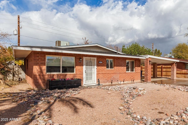 single story home featuring a patio area, fence, and brick siding