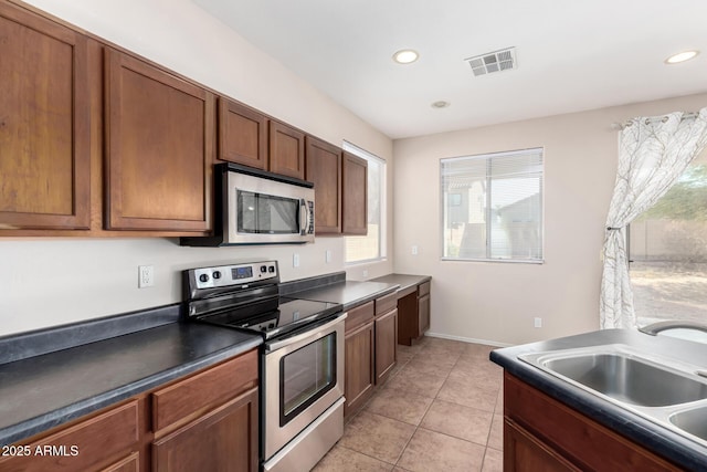 kitchen with sink, light tile patterned floors, and appliances with stainless steel finishes