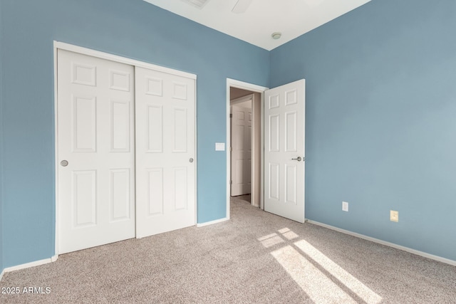 unfurnished bedroom with light colored carpet, a closet, and ceiling fan