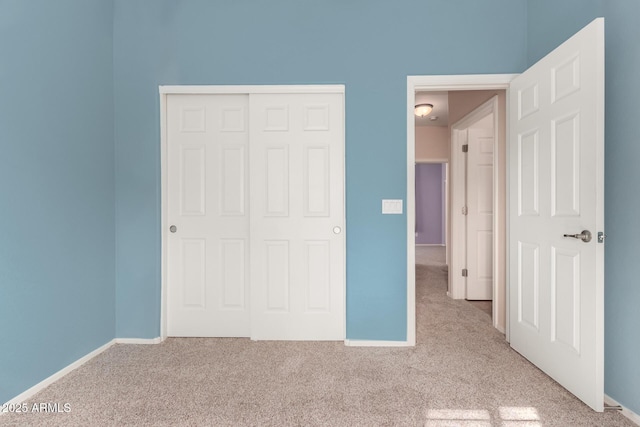 unfurnished bedroom with a closet and light carpet