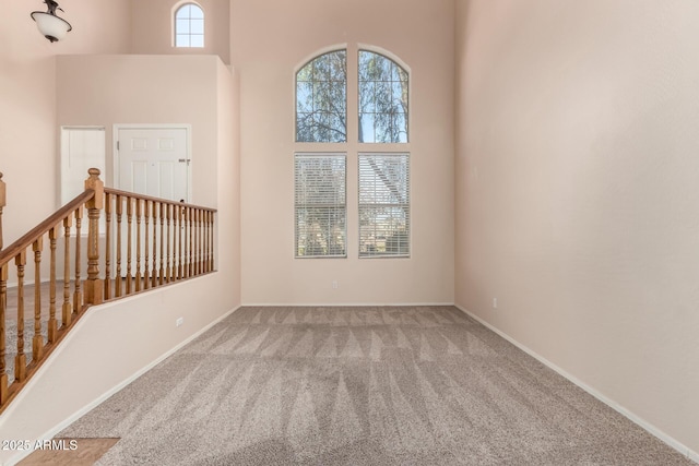 unfurnished room with carpet and a high ceiling