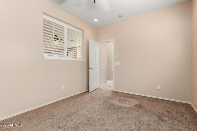 carpeted spare room with ceiling fan