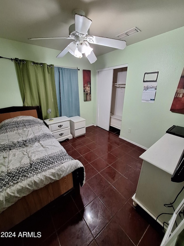 tiled bedroom featuring ceiling fan and a closet