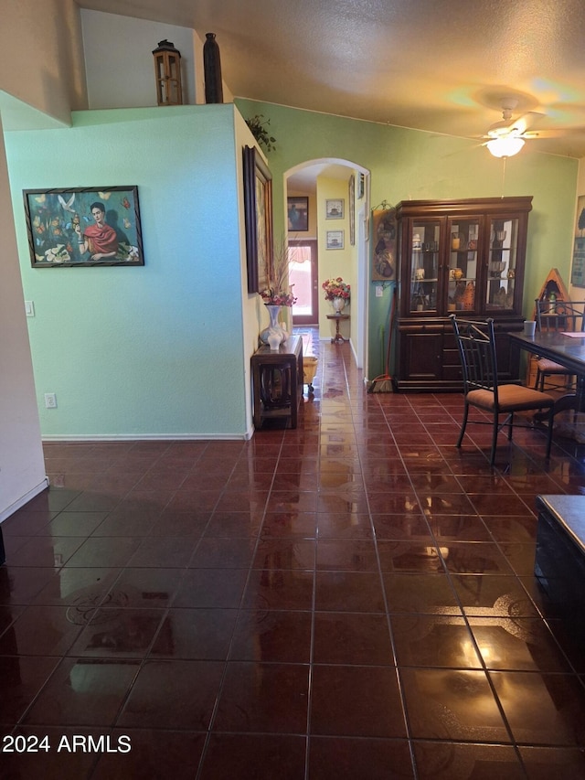 corridor with dark tile patterned flooring and a textured ceiling