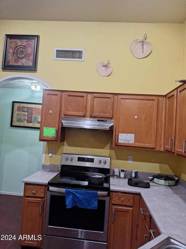 kitchen with electric stove and dark tile patterned flooring