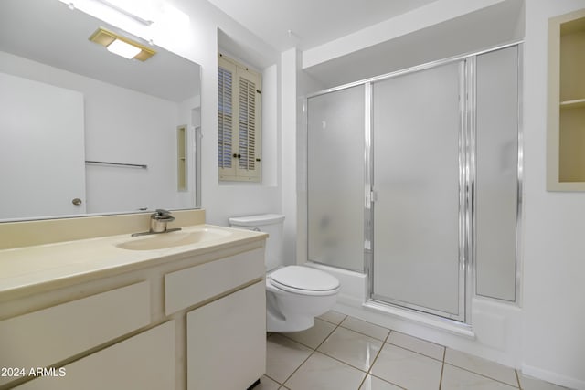 full bathroom featuring tile patterned floors, vanity, bath / shower combo with glass door, and toilet