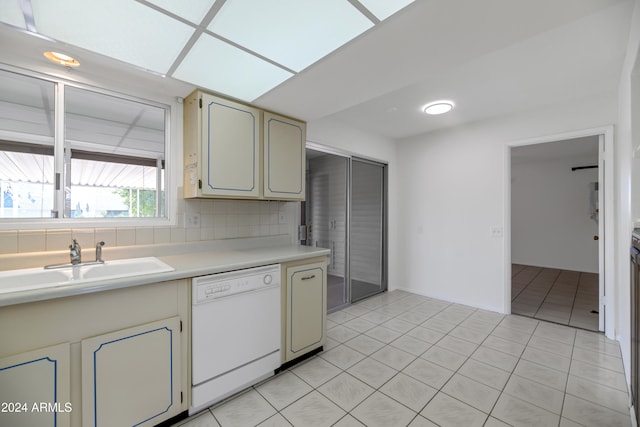 kitchen featuring cream cabinets, white dishwasher, sink, decorative backsplash, and light tile patterned flooring