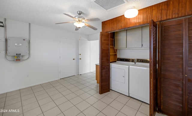 laundry area with cabinets, a textured ceiling, ceiling fan, light tile patterned floors, and washing machine and dryer