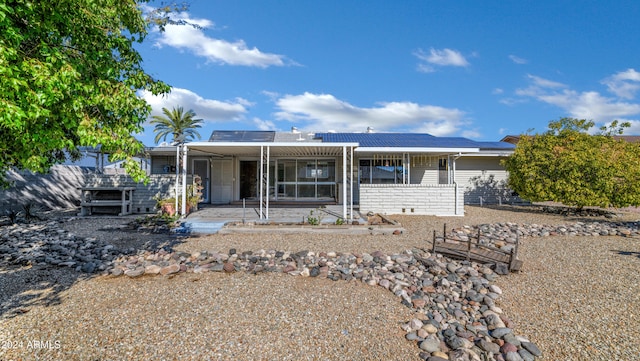 ranch-style home featuring solar panels