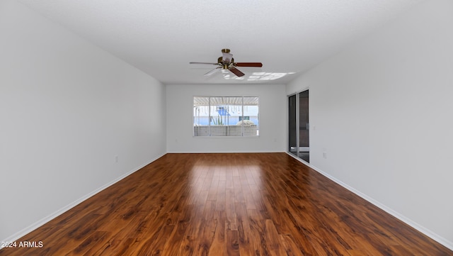 empty room featuring ceiling fan and dark hardwood / wood-style floors