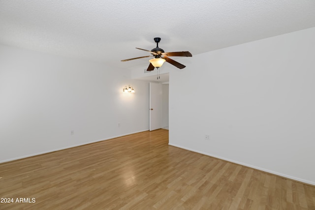 empty room featuring ceiling fan, light hardwood / wood-style floors, and a textured ceiling