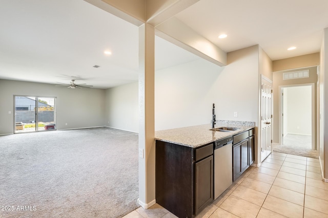 kitchen featuring ceiling fan, light colored carpet, dishwasher, sink, and dark brown cabinetry