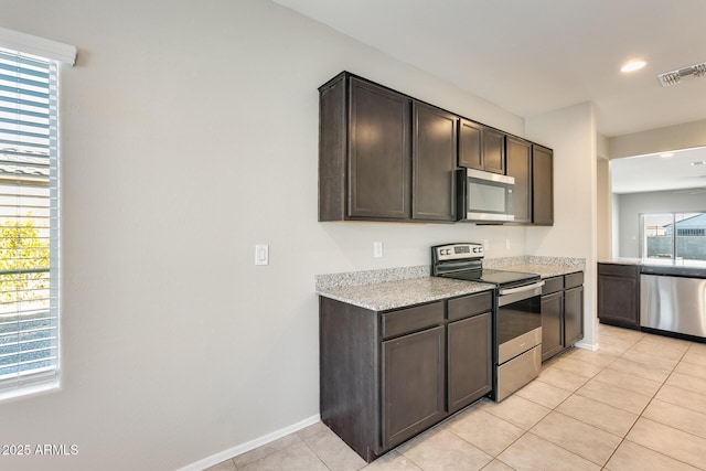 kitchen featuring dark brown cabinetry, appliances with stainless steel finishes, and light tile patterned flooring