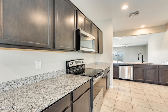 kitchen featuring light tile patterned floors, ceiling fan, stainless steel appliances, dark brown cabinetry, and sink