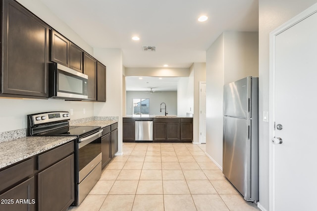 kitchen with dark brown cabinetry, sink, stainless steel appliances, and ceiling fan