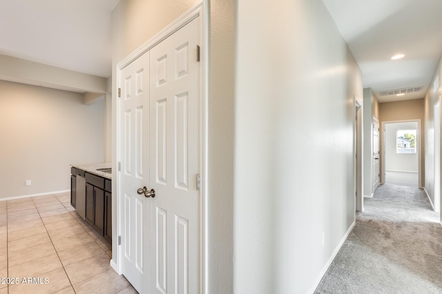 corridor featuring light colored carpet