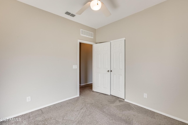 unfurnished bedroom featuring ceiling fan, a closet, and carpet floors