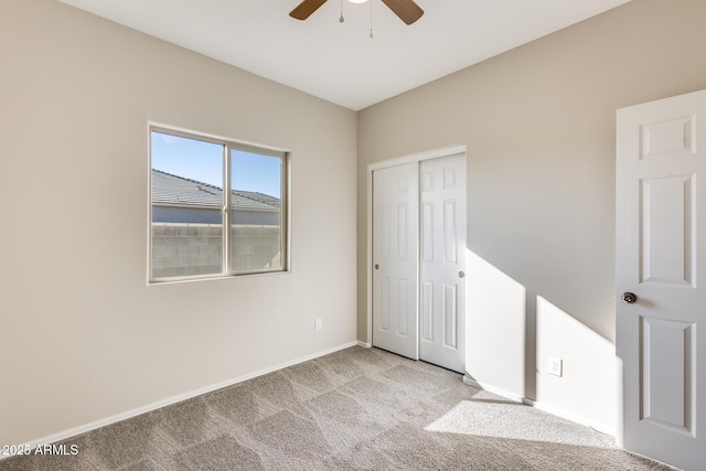 carpeted spare room featuring ceiling fan