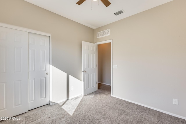 unfurnished bedroom with ceiling fan, a closet, and carpet floors