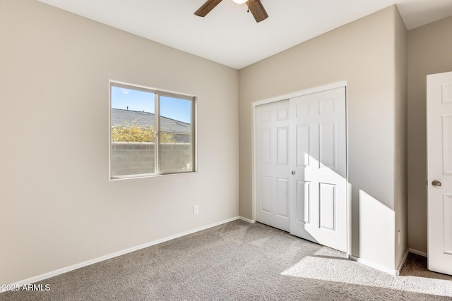 unfurnished bedroom with ceiling fan, carpet, and a closet